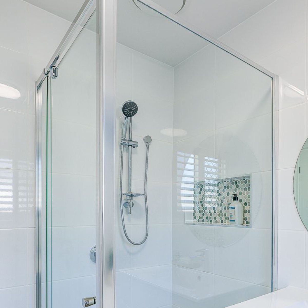 Full framed shower screen with a shower rail and tiled niche
